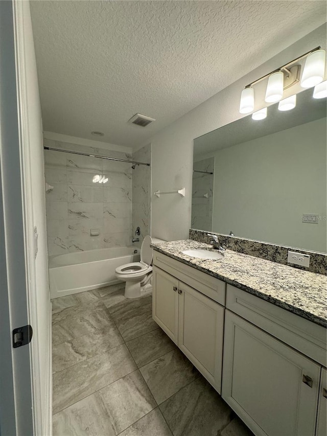 full bathroom featuring vanity, a textured ceiling, tiled shower / bath combo, and toilet