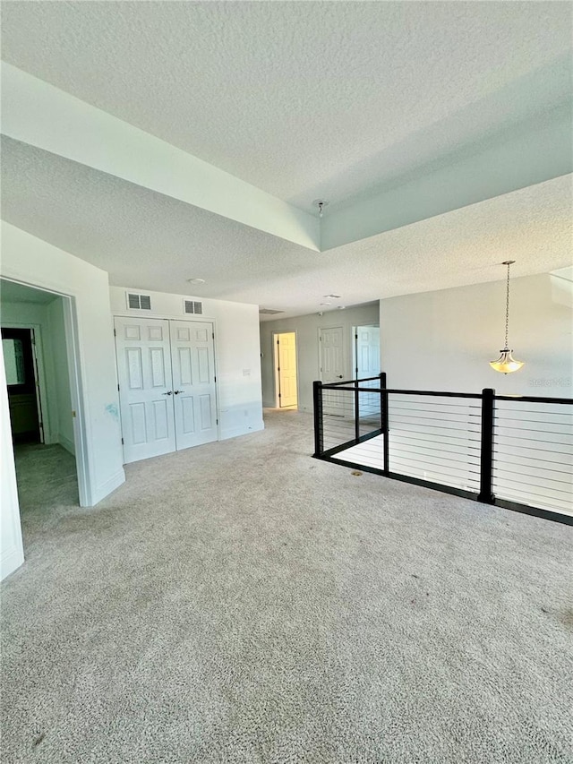 spare room with carpet flooring and a textured ceiling