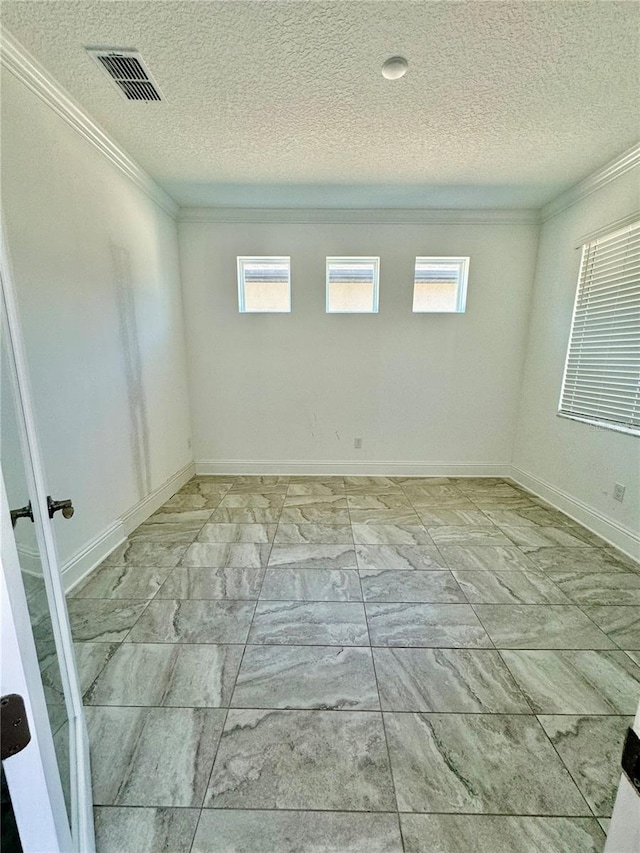 empty room featuring a wealth of natural light and a textured ceiling