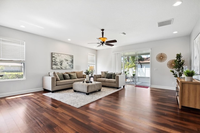 living room featuring dark hardwood / wood-style flooring, ceiling fan, and a healthy amount of sunlight