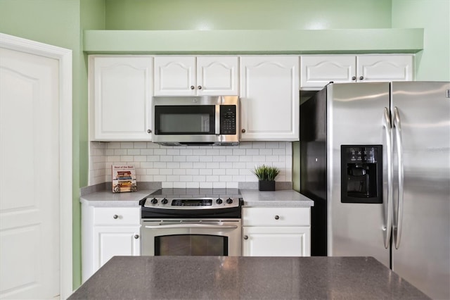 kitchen featuring appliances with stainless steel finishes, tasteful backsplash, and white cabinetry