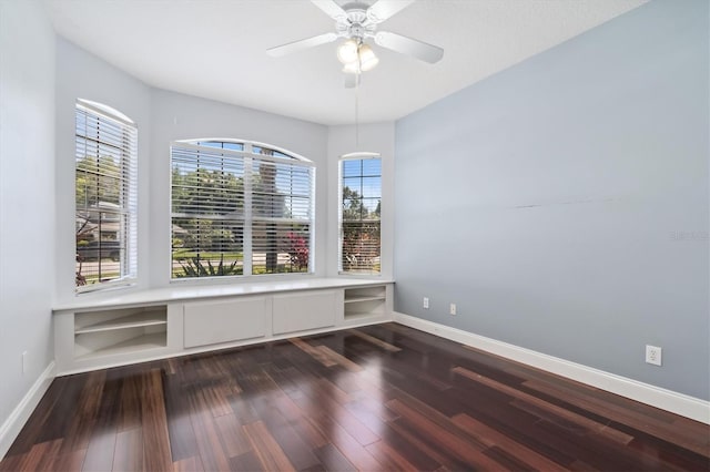 unfurnished room featuring ceiling fan, plenty of natural light, and dark wood-type flooring