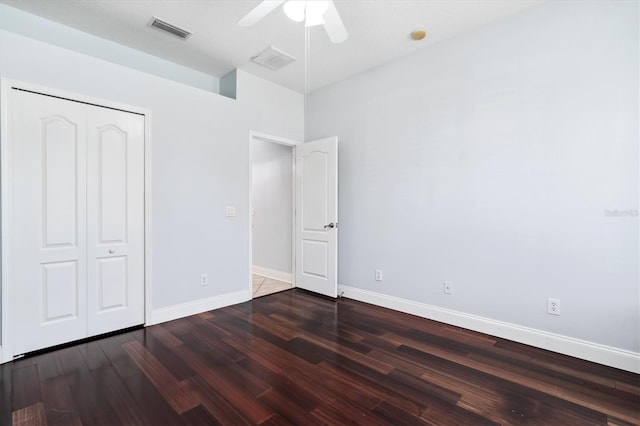 unfurnished bedroom with a closet, ceiling fan, and dark hardwood / wood-style flooring