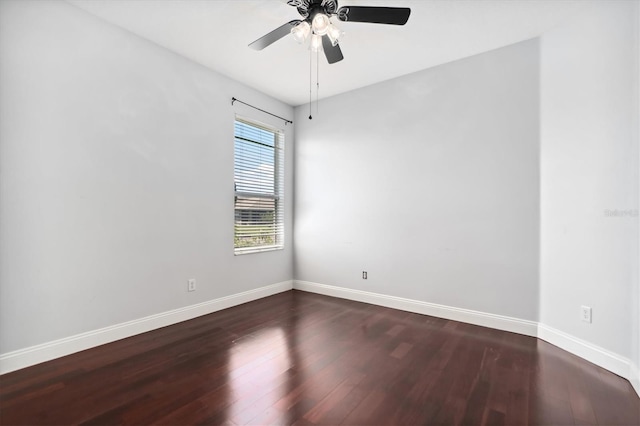 spare room with dark hardwood / wood-style flooring and ceiling fan