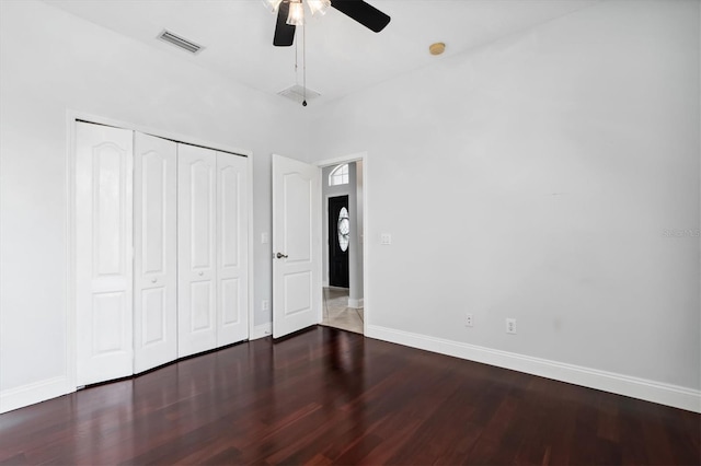 unfurnished bedroom with a closet, ceiling fan, and dark hardwood / wood-style flooring