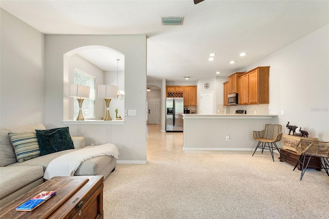 living room featuring light colored carpet and a notable chandelier