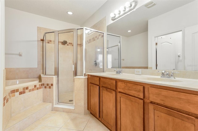 bathroom with dual bowl vanity, tile floors, and shower with separate bathtub