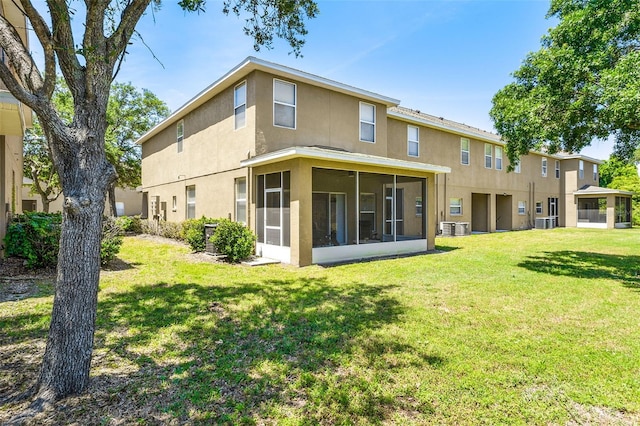 rear view of property with a yard and a sunroom