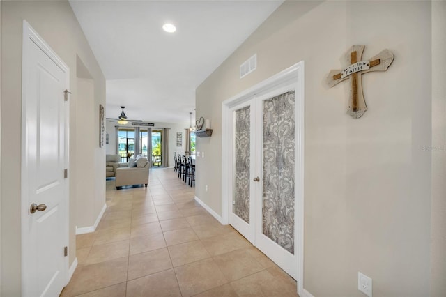 hall featuring french doors and light tile floors