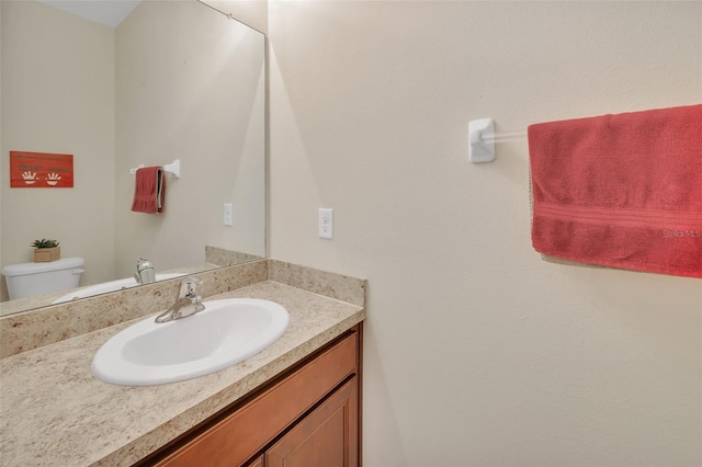 bathroom with toilet and large vanity