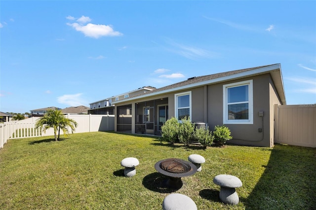 back of property with a sunroom and a lawn