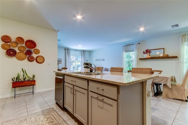 kitchen featuring sink, a kitchen island with sink, light tile patterned floors, and gray cabinets