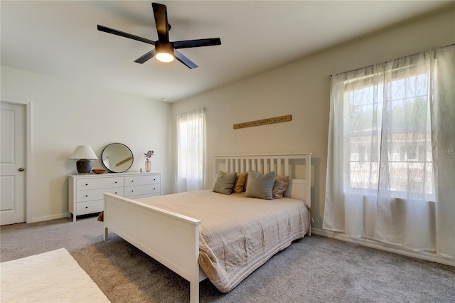 carpeted bedroom featuring ceiling fan and multiple windows