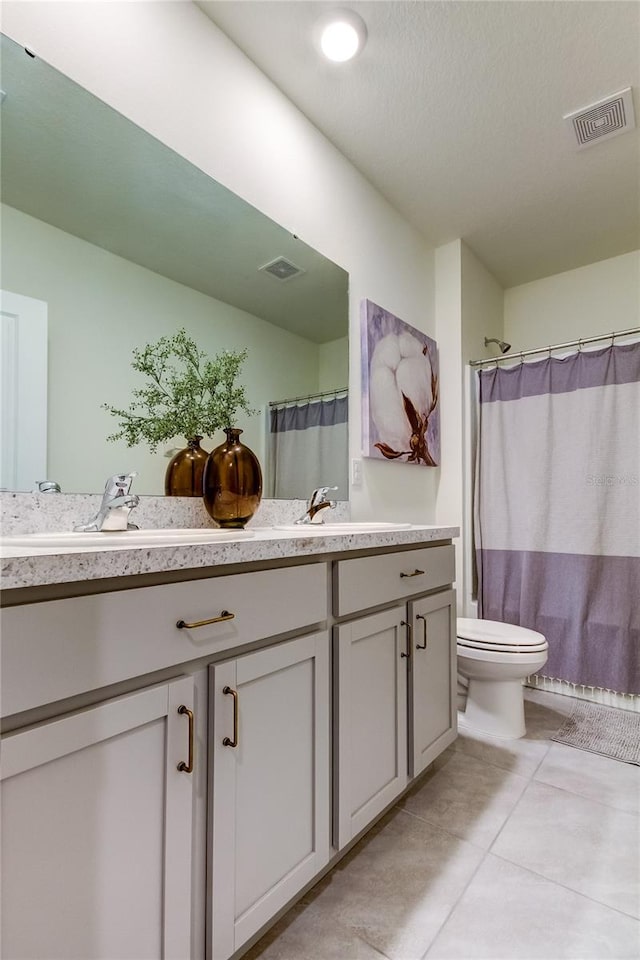 bathroom with toilet, vanity, a shower with curtain, and tile patterned flooring