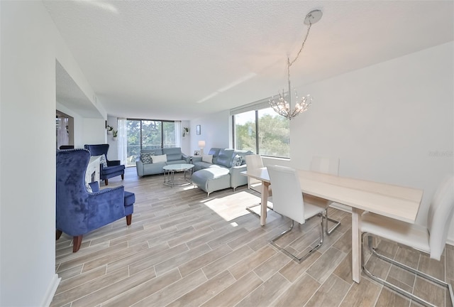 dining space featuring a textured ceiling, light wood-type flooring, and a chandelier