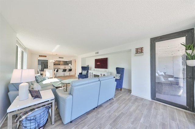 living room with light hardwood / wood-style flooring and a textured ceiling