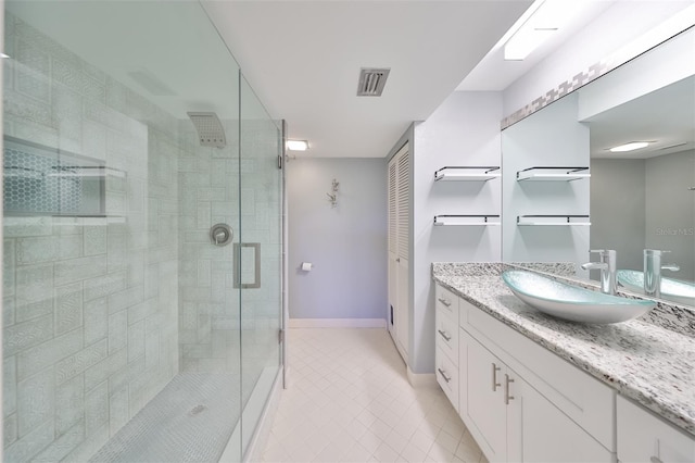 bathroom featuring vanity with extensive cabinet space, an enclosed shower, and tile flooring