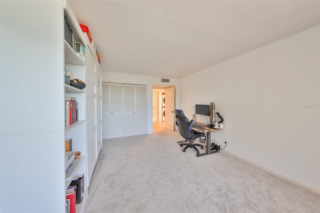 carpeted office featuring a textured ceiling