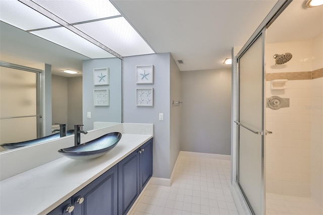 bathroom with a shower with door, tile flooring, and vanity