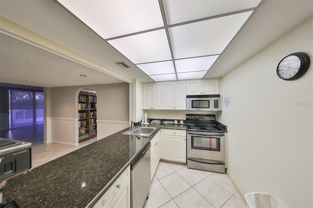 kitchen with white cabinetry, light tile floors, and stainless steel appliances