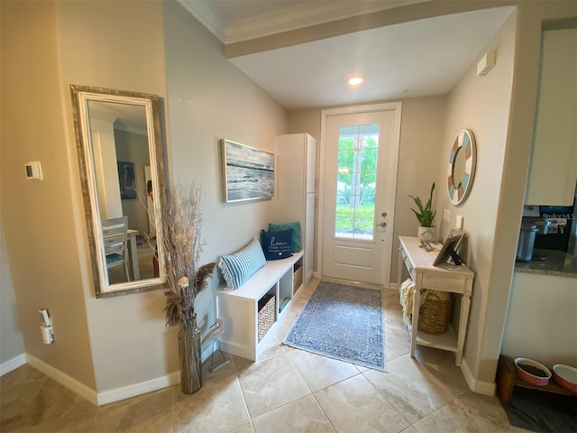 entryway with ornamental molding and light tile patterned floors