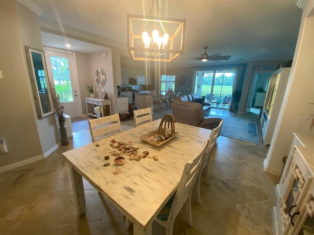 tiled dining room with ornamental molding and ceiling fan with notable chandelier