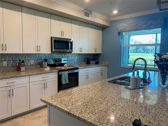 kitchen featuring sink, crown molding, white cabinets, appliances with stainless steel finishes, and tasteful backsplash