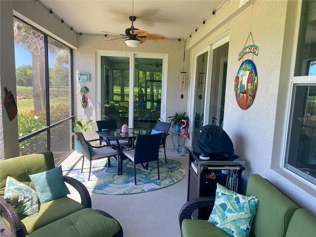 sunroom / solarium featuring a healthy amount of sunlight and ceiling fan