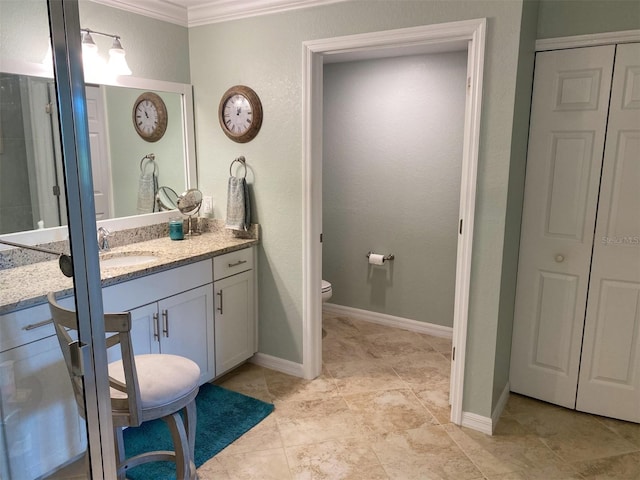 bathroom featuring toilet, ornamental molding, and vanity