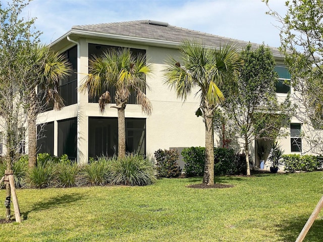 view of home's exterior featuring a sunroom and a lawn