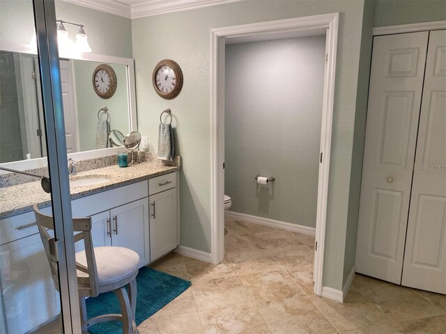 bathroom featuring crown molding, vanity, and toilet