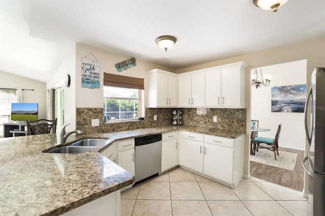 kitchen with sink, backsplash, white cabinetry, stainless steel appliances, and dark stone countertops