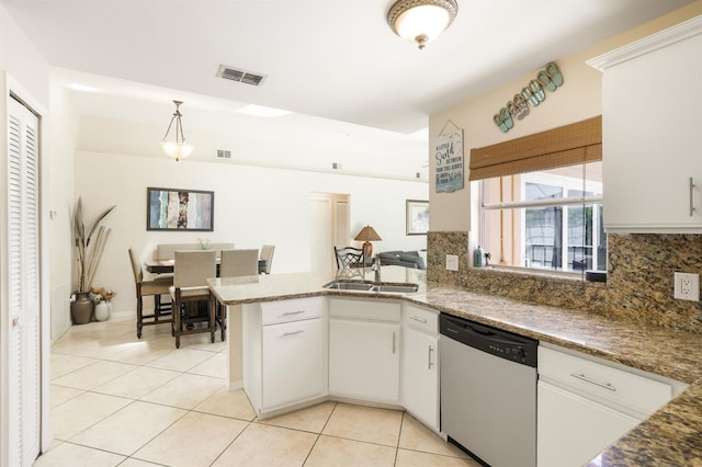 kitchen featuring stone counters, kitchen peninsula, backsplash, white cabinetry, and stainless steel dishwasher