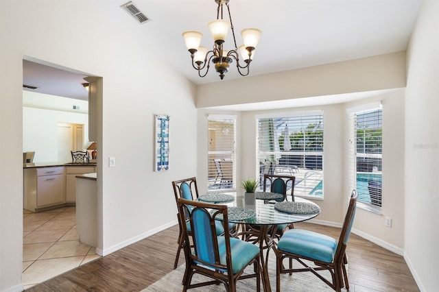 tiled dining area featuring a chandelier