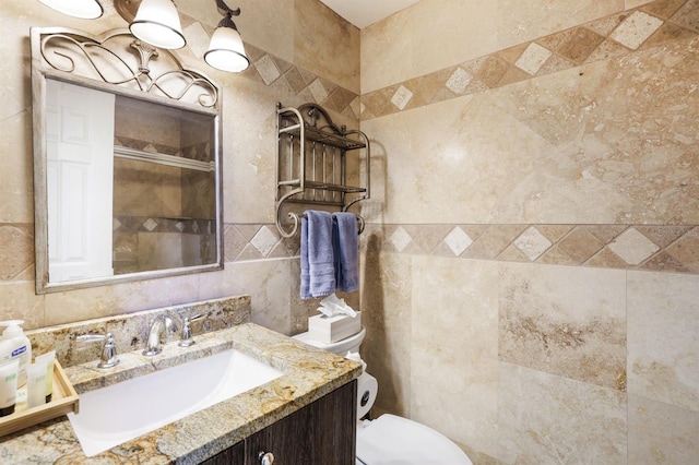 bathroom featuring tile walls, vanity, and toilet