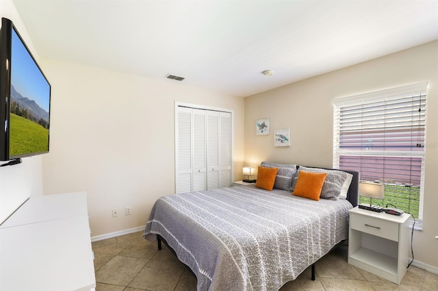 bedroom featuring a closet and light tile floors