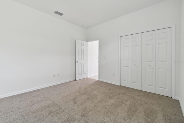 unfurnished bedroom featuring carpet floors and a closet