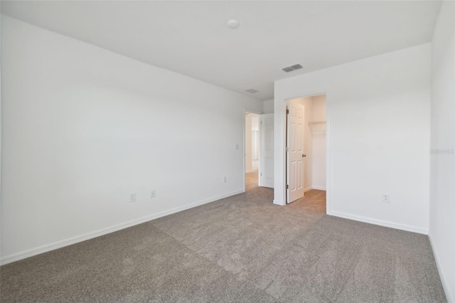 unfurnished bedroom featuring a spacious closet, carpet floors, and a closet