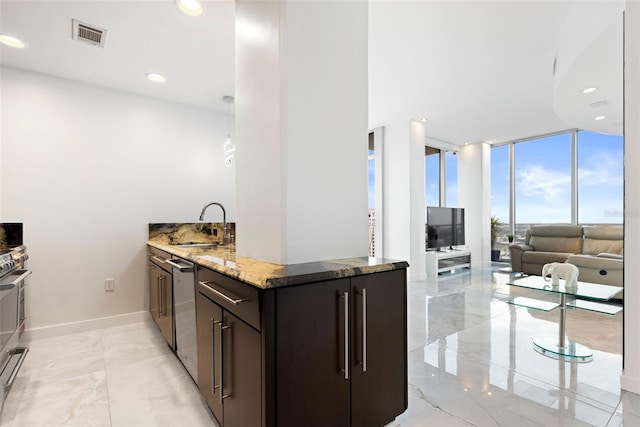 kitchen featuring stone countertops, sink, a wall of windows, and dark brown cabinets