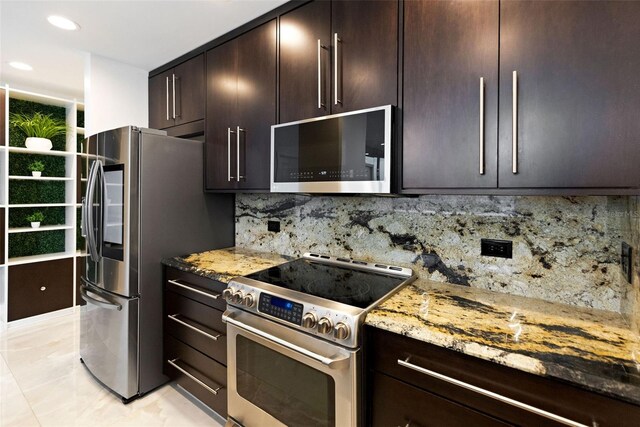 kitchen featuring light tile patterned floors, appliances with stainless steel finishes, tasteful backsplash, light stone counters, and dark brown cabinetry