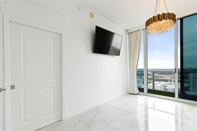 unfurnished room with floor to ceiling windows and a chandelier