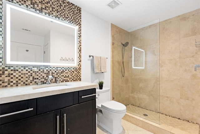 bathroom with vanity, tiled shower, toilet, decorative backsplash, and tile patterned floors