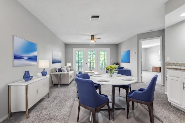 dining area featuring ceiling fan, carpet, french doors, and a textured ceiling