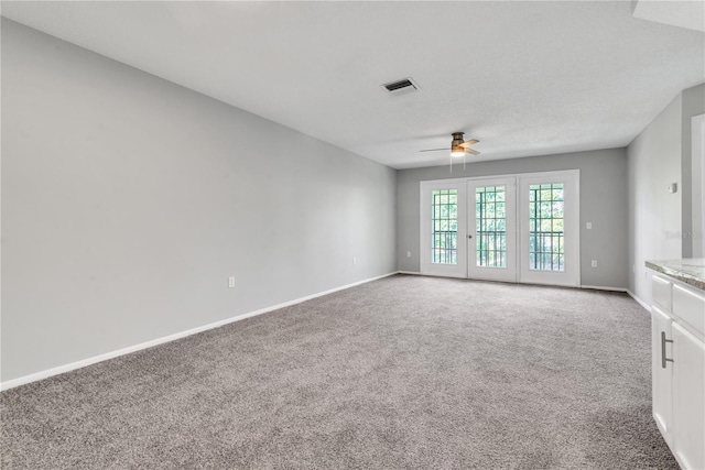 carpeted empty room with ceiling fan and a textured ceiling