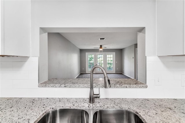 kitchen with white cabinets, sink, ceiling fan, and backsplash