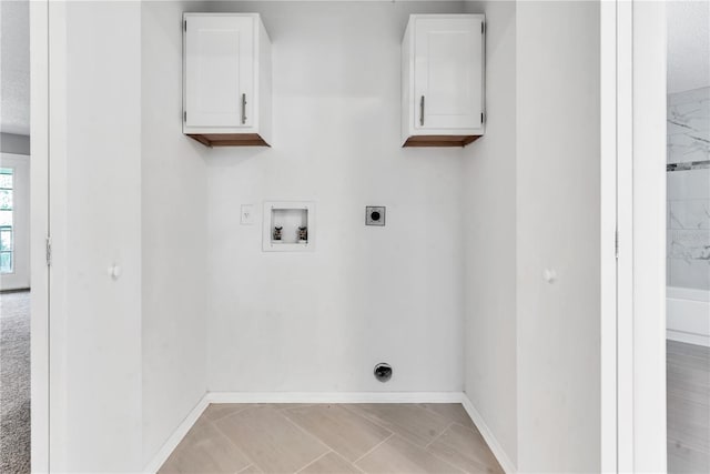 laundry room with cabinets, light tile flooring, washer hookup, and electric dryer hookup