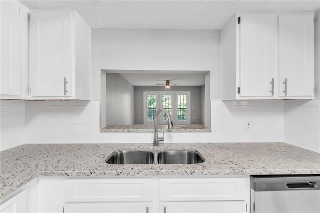 kitchen featuring ceiling fan, sink, tasteful backsplash, white cabinetry, and stainless steel dishwasher