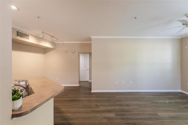 spare room featuring ceiling fan, ornamental molding, track lighting, and dark wood-type flooring