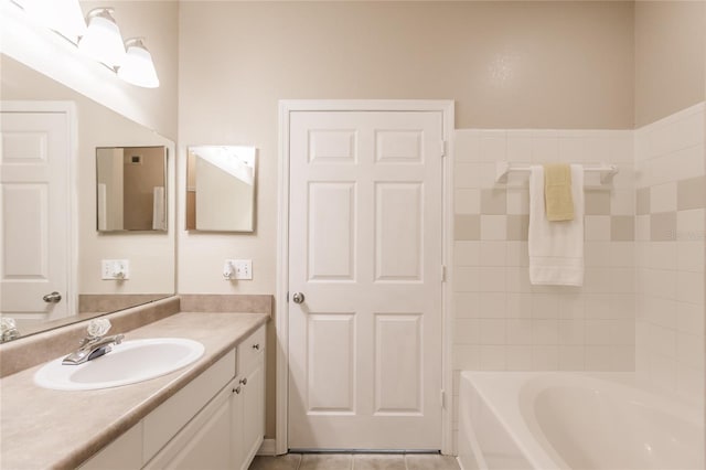 bathroom featuring tile patterned flooring, vanity, and a tub