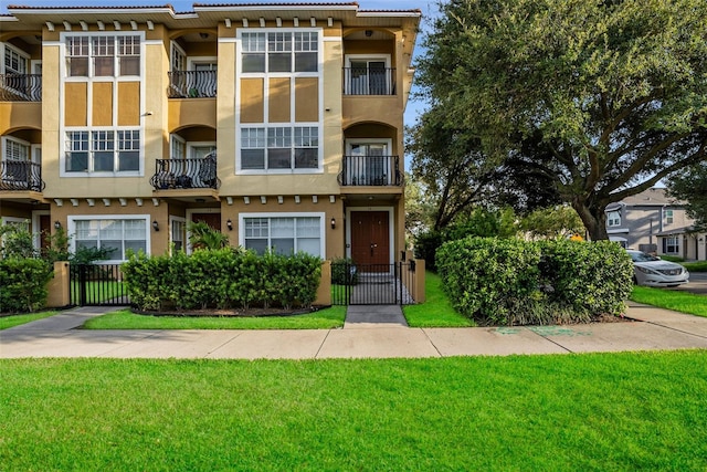 view of front facade with a front yard and a balcony